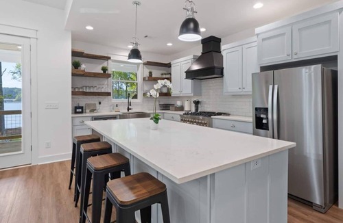 Eatonton House | Enjoy a modern Lake Sinclair retreat with two king beds, a private putting green, kayaks, and a game room.