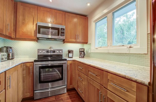 Twin Oaks House | Palm-surrounded abode with screened-in balcony, chef's kitchen, smart TVs, & W/D